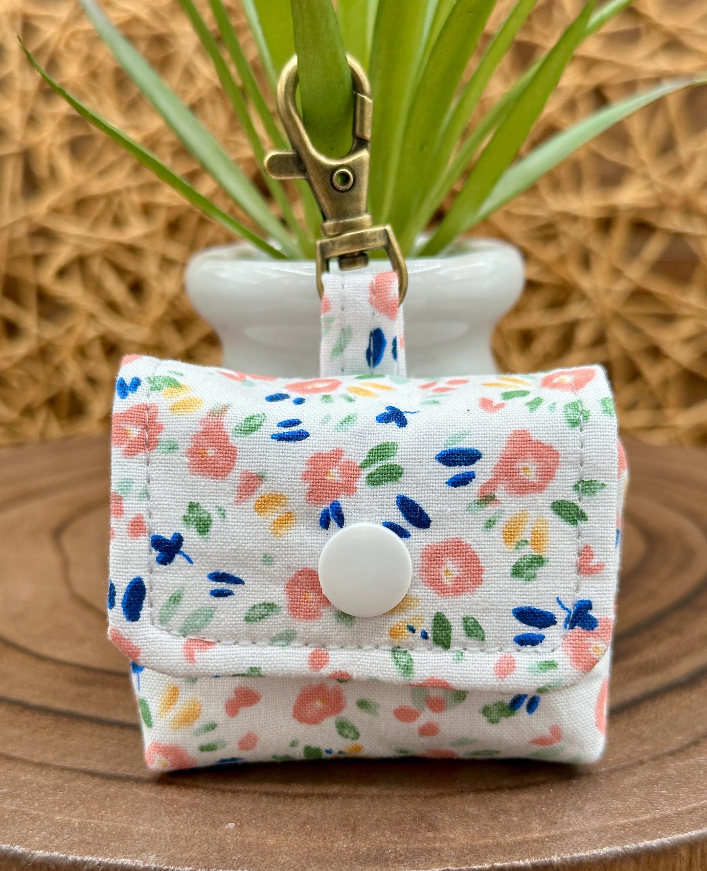 Wireless earbud case, Dainty Pink floral fabric With Blue Leaves; snap closure and swivel clasp for stylish convenience and security 3X3X.75