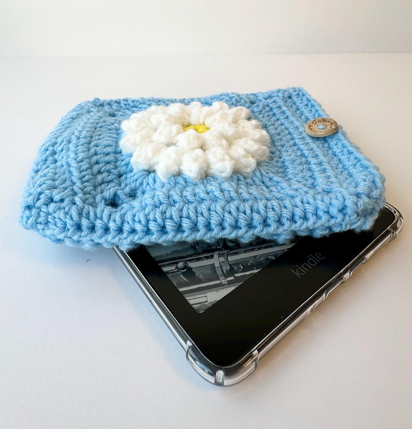 Blue Crocheted Kindle Sleeve with White Flower Granny Square & Wood Button, Handmade E-Reader Cover, Gift for Book Lovers measures 7.5 X 5.5