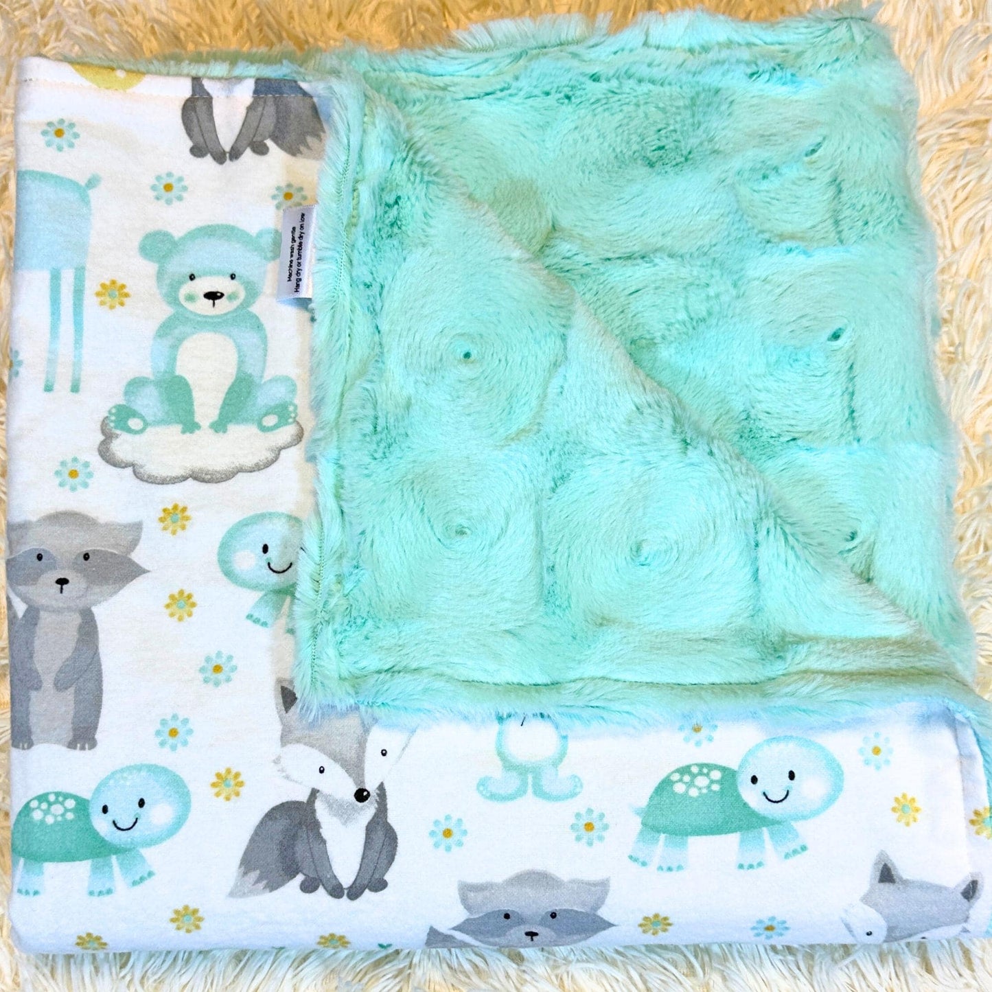 plush green swirl minky baby blanket featuring a cotton flannel flip side with adorable bears, foxes, racoons and turtles