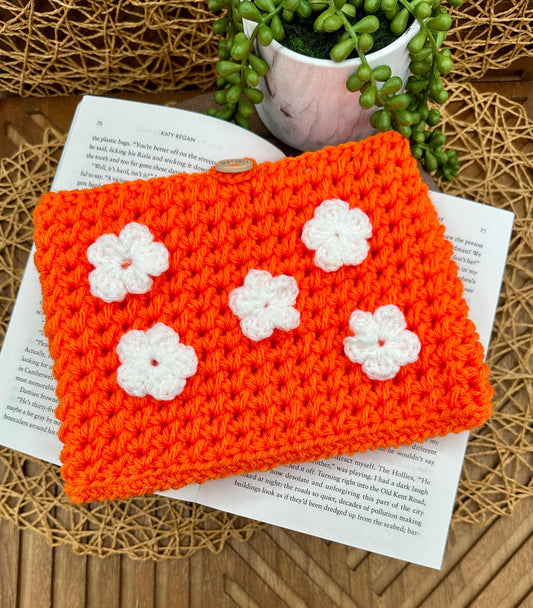 orange crocheted book sleeve with five white flowers