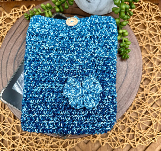 blue multi-colored crocheted kindle paperwhite sleeve featuring a bow and wood button closure