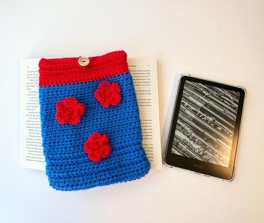 red and blue crocheted book sleeve with three flowers