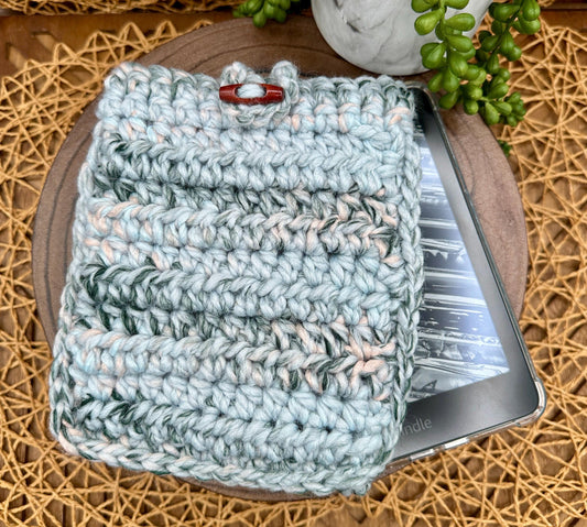 thick blue pink and gray crocheted kindle paperwhite sleeve featuring a wood toggle button closure