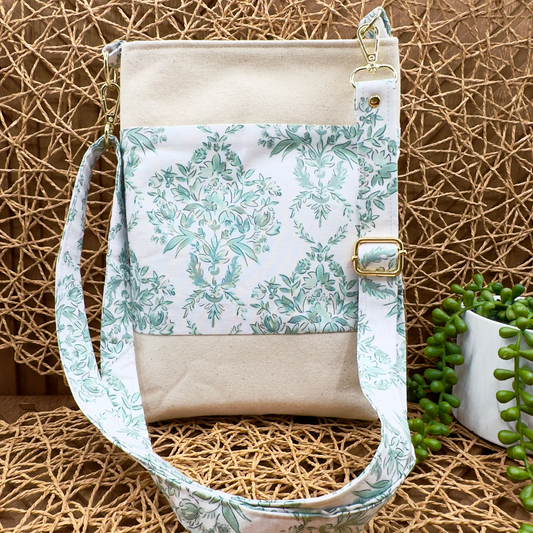light beige canvas North South small crossbody bag, featuring a green floral accent print