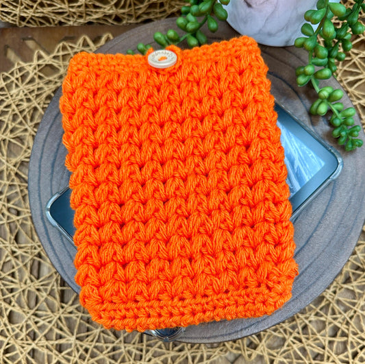 orange crocheted kindle paperwhite sleeve with a wood button closure